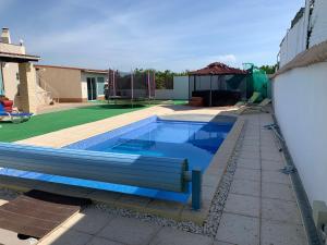 una piscina con un banco en el patio trasero en Tavira Unterkunft Entspannung pur!!!, en Luz de Tavira