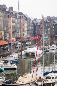 grupa łodzi zacumowanych w porcie z budynkami w obiekcie Centrally located, refurbished modern flat with views over the historic port w mieście Honfleur