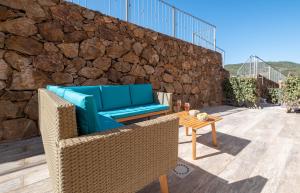 une terrasse avec un canapé bleu et une table dans l'établissement [SEA 10MIN] Modern house with pool in the hills, à San Teodoro