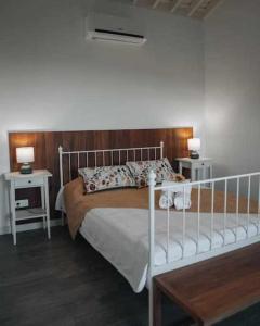 a bedroom with a white bed with a wooden headboard at Casas do Forneiro O Horizonte T2 in Nordeste