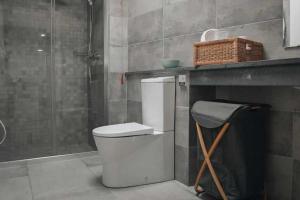 a bathroom with a toilet and a sink and a basket at Casas do Forneiro O Horizonte T2 in Nordeste