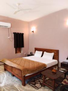 ein Schlafzimmer mit einem großen Bett und einem Tisch in der Unterkunft Sadhna Sadan stay mountain and river view Panna tiger reserve in Rājgarh