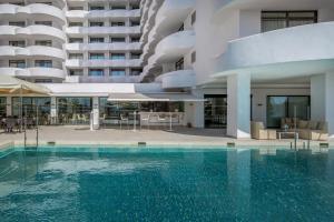 a swimming pool in front of a building at Hotel Palma Bellver , Affiliated by Meliá in Palma de Mallorca