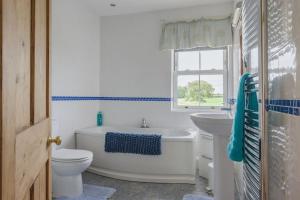 a bathroom with a tub and a toilet and a sink at Bainvalley Cottages, Beautiful North Cottage in Lincolnshire