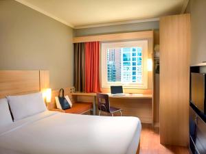 a hotel room with a bed and a desk and a window at ibis Santiago Las Condes Manquehue in Santiago