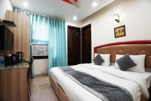 a bedroom with a large bed and a television at Hotel S & B East Inn - Patel Nagar in New Delhi