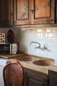 - un comptoir de cuisine avec un évier et une chaise dans l'établissement Casa Rural Moli, à Rosell