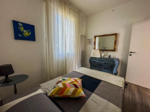 1 dormitorio con cama, tocador y espejo en Casa Mirella, en Cavallino-Treporti