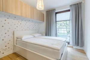 1 dormitorio con cama blanca y ventana en Imperial Apartments - Mewa en Sopot