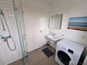 a bathroom with a washing machine and a toilet at Moderne Penthouse Wohnung in Schleswig