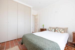 - une chambre avec un lit blanc et des armoires blanches dans l'établissement WHome Countryside Charm Near Wedding Venue w/ BBQ Patio, à Torres Vedras