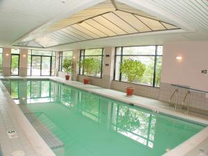 ein großer Pool mit grünem Wasser in einem Gebäude in der Unterkunft Hyatt Regency Lisle near Naperville in Lisle