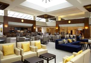 a lobby with couches and tables and a restaurant at Hyatt Regency Lisle near Naperville in Lisle