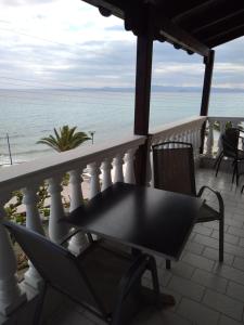 a table and chairs on a balcony overlooking the ocean at Polychrono Beach Hotel in Polykhrono
