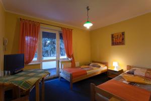 1 dormitorio con 2 camas y ventana en Hotelik Villa en Legnica