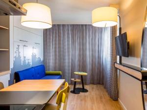 une petite salle à manger avec une table et une chaise bleue dans l'établissement Aparthotel Adagio access Montpellier Centre, à Montpellier
