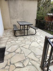 - une table de pique-nique et un banc sur une terrasse en pierre dans l'établissement Hôtel Les 4 Chênes, à Pontault-Combault