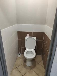 uma casa de banho com um WC branco numa cabina em Hôtel Les 4 Chênes em Pontault-Combault