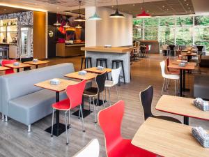 a restaurant with tables and chairs and a counter at ibis Juiz de Fora in Juiz de Fora
