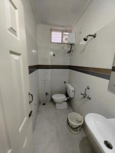 Baño blanco con aseo y lavamanos en NK Homes -Serviced Apartments - 2 BHK Homestay, Fast Wifi, Fully Furnished, en Hyderabad
