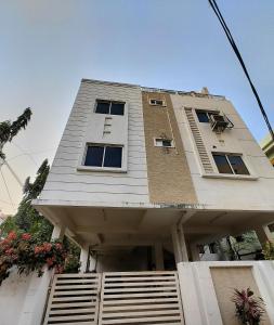 ein hohes weißes Gebäude mit einer Treppe davor in der Unterkunft NK Homes -Serviced Apartments - 2 BHK Homestay, Fast Wifi, Fully Furnished in Hyderabad