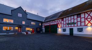 a large barn with a red and white building at Gut Magdalenenhof in Laufersweiler