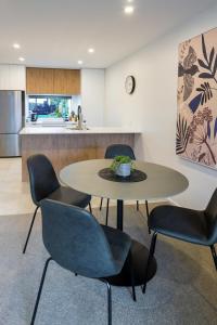 una sala da pranzo con tavolo e sedie e una cucina di City Lights Retreat with Carpark 2 Bed 2 Bath a Christchurch