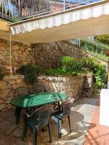 una mesa verde y sillas en un patio en La casa di Max en La Spezia