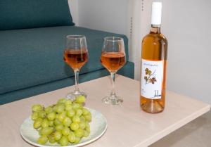 dos copas de vino y un plato de uvas en una mesa en Elafonisi Village, en Elafonisi
