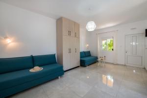 a living room with a blue couch and two chairs at Elafonisi Village in Elafonisi