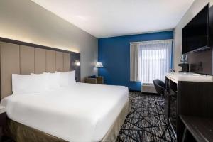 a large white bed in a room with blue walls at Baymont by Wyndham LaVergne in La Vergne