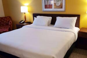 un grande letto bianco in una camera d'albergo di Wingate by Wyndham Uniontown a Uniontown