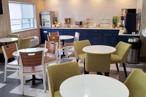 un restaurant avec des tables et des chaises et une cuisine dans l'établissement Wingate by Wyndham Uniontown, à Uniontown