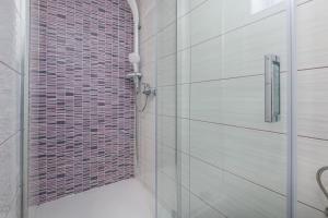 a shower with a glass door in a bathroom at Nice apartment with balcony very close to the sea in Klimno
