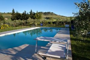 una piscina con 2 sillas frente a ella en Casale Colomba, en Buseto Palizzolo
