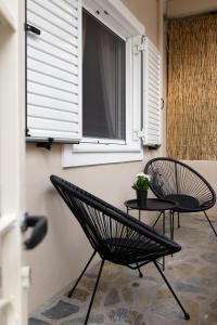 2 chaises et une table sous une fenêtre dans l'établissement Irida’s detached house with lovely garden/yard in Athens city center, à Athènes