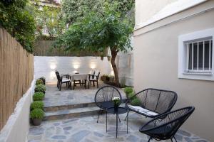 d'une terrasse avec des chaises et une table dans l'arrière-cour. dans l'établissement Irida’s detached house with lovely garden/yard in Athens city center, à Athènes