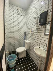 een badkamer met een toilet en een wastafel bij Sue Cottage Homestay in Jertih