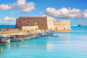 een groep boten in het water naast een kasteel bij Knossos House in Heraklion