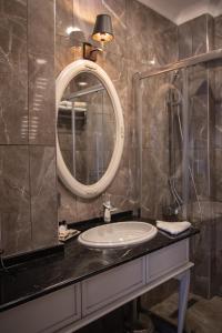 W łazience znajduje się umywalka i lustro. w obiekcie Louis Rooms w Stambule