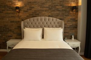 um quarto com uma cama grande e uma parede de tijolos em Louis Rooms em Istambul