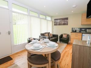 a kitchen and living room with a table and chairs at 107 Kings Chalet Park in Cromer