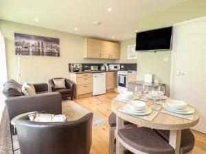 a kitchen and living room with a table and chairs at 107 Kings Chalet Park in Cromer