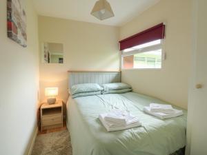 a bedroom with a bed with two towels on it at 107 Kings Chalet Park in Cromer