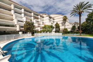 a large swimming pool in front of a building at Roy Boston Marbella by Florentia Homes in Marbella