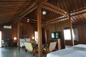Habitación con cama y TV. en Ijen Estate Resort And Villa, en Dadapan