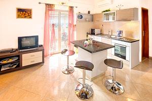 a kitchen with a counter and stools in a room at Apartmani Rita in Milna