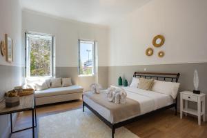 a bedroom with a bed and a couch and windows at Dimora di Stile in Corfu Town