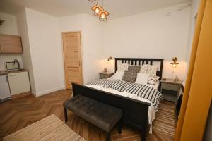 a bedroom with a bed and a bench in it at Nana’s Vendégház in Mád