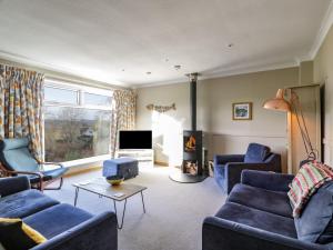 a living room with blue furniture and a fireplace at Millbrook Cottage in Dalbeattie
